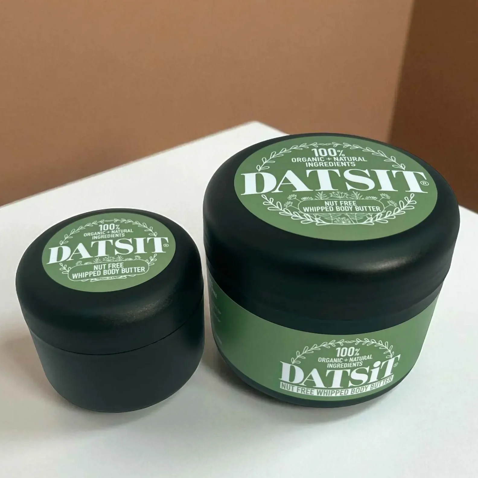Two jars of Datsit organic nut free whipped body butter, one 50ml jar, and one 150ml jar on a muted background with soft shadows